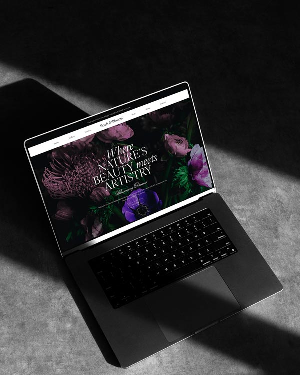 Example of florist website presented on the laptop. Beautiful background with flowars and custom fonts create eye-caching design.